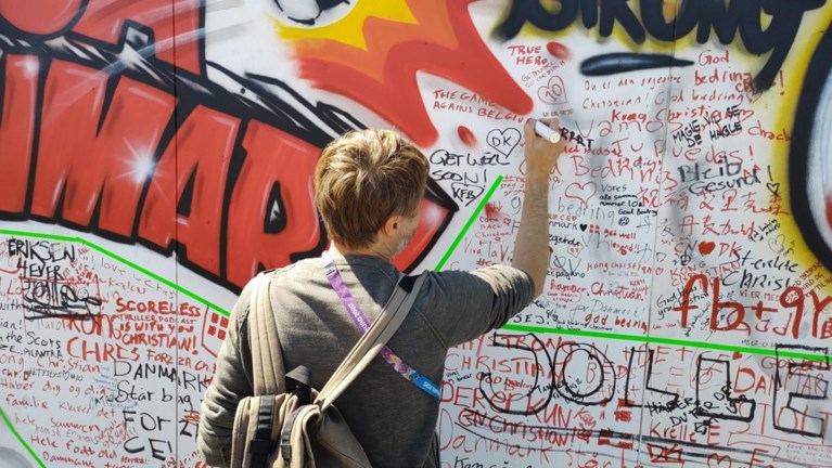 Onze reporters trokken op bedevaart met Deense fans naar de muur van Eriksen: “De match tegen de dood hebben we al gewonnen”
