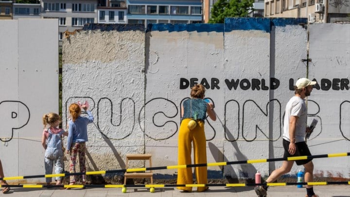 Ouders en kinderen geven kleur aan kunstwerk gericht aan wereldleiders: “Ik zou niet met de toekomst van mijn kind willen ruilen”